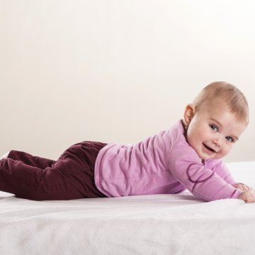 Baby on a mattress smilin